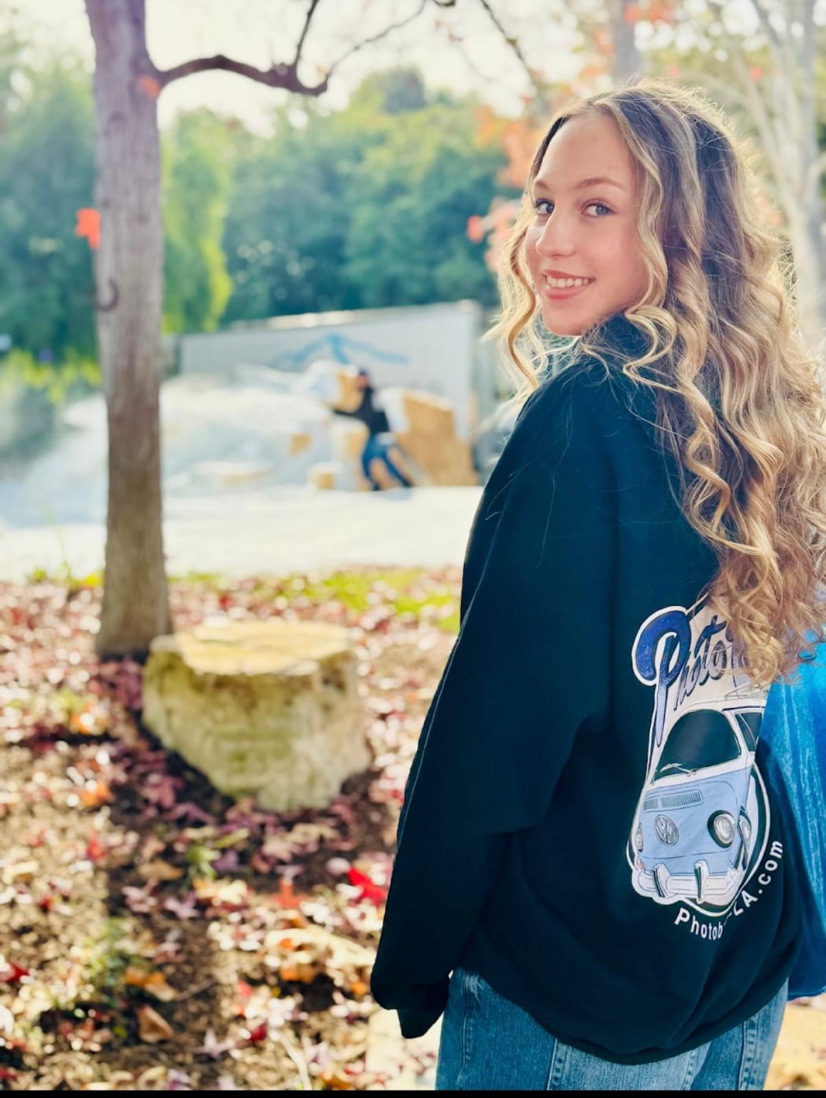 Young woman wearing a Photobus-LA branded sweatshirt with the VW bus logo on the back