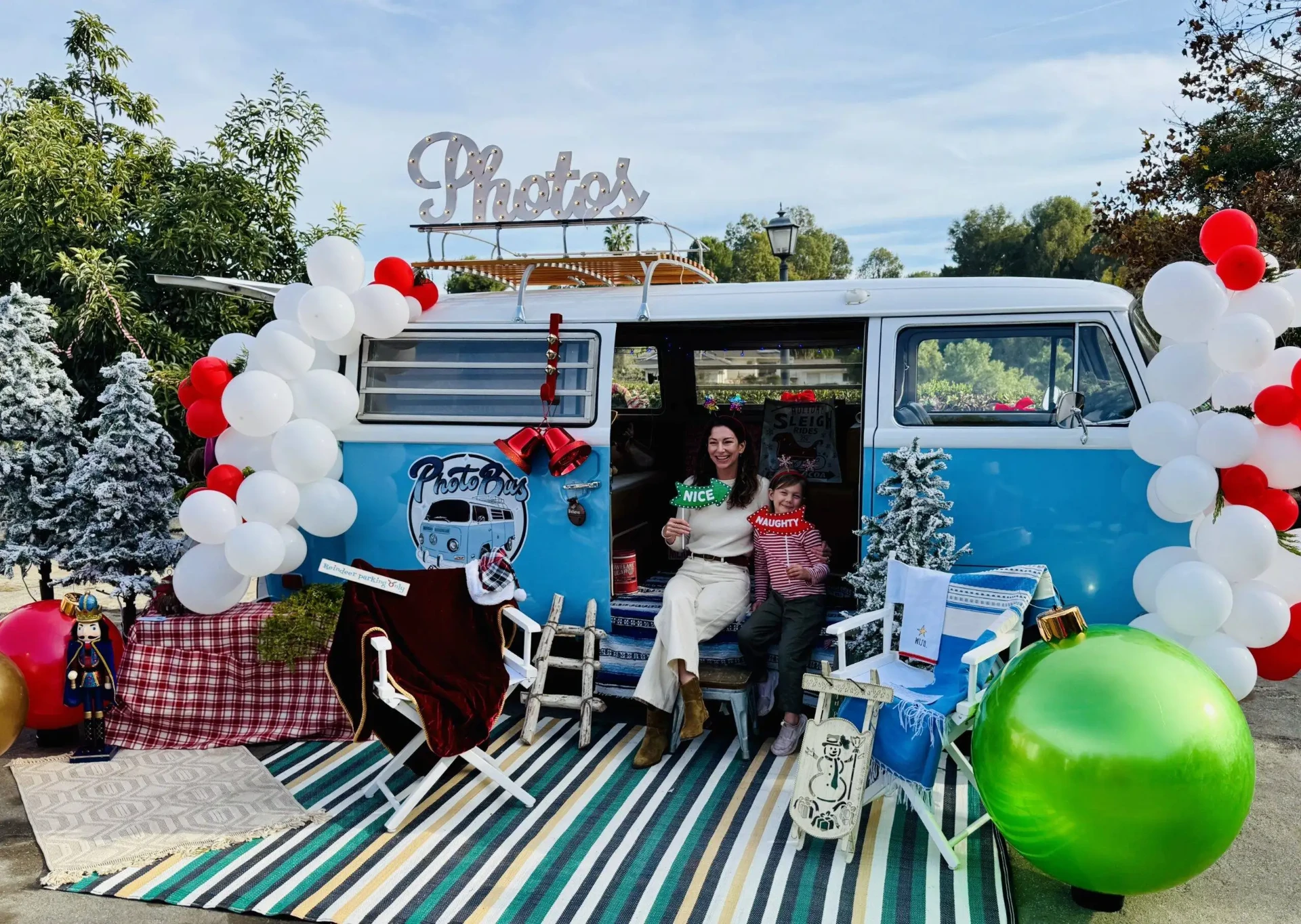 Mother and daughter holding props in the open doorway of the vintage Photobus
